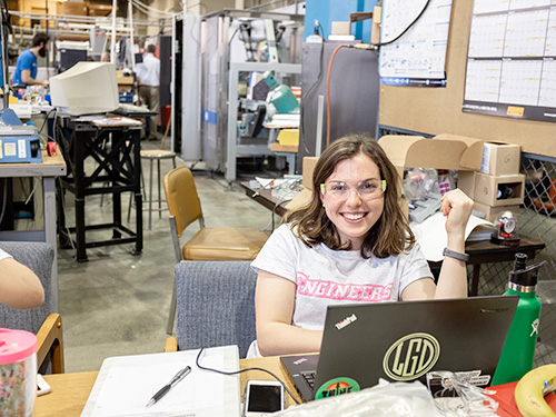 Undergraduate student works at a laptop with safety goggles