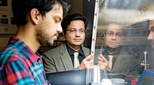 Professor Koratkar works with student in lab