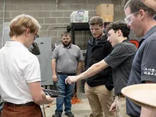 Students work with a professor on a project