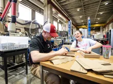 Two students work with cardboard in the MILL